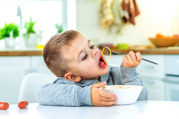 istock children in the kitchen at the table turning pasta. 1471622192