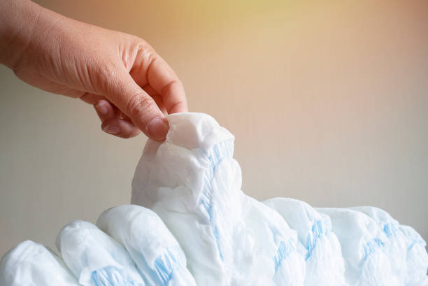 istock A Pacifier's hand takes a diaper-panties on a light beige background. 1471625013