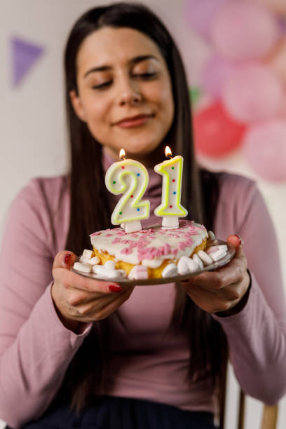 istock A Young Woman Holds a Birthday Cake Surrounded by Decorations 1471625599
