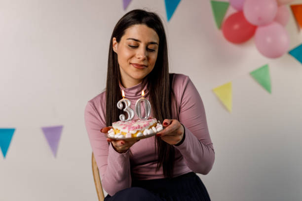 istock Cake time, female with 30th birthday cake and candles 1471626032