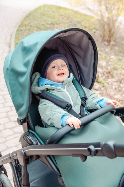 istock Smiling baby child in a stroller in the spring park 1471627759