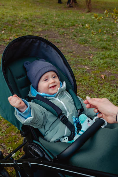 istock Smiling baby child in a stroller in the spring park 1471627784