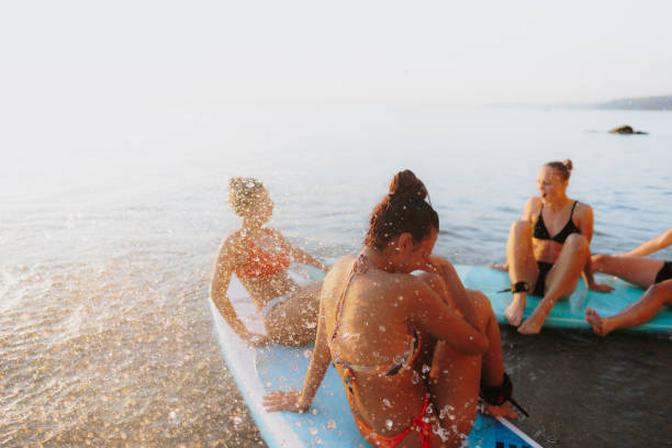 suping et natation - surfing teenage girls friendship sunset photos et images de collection