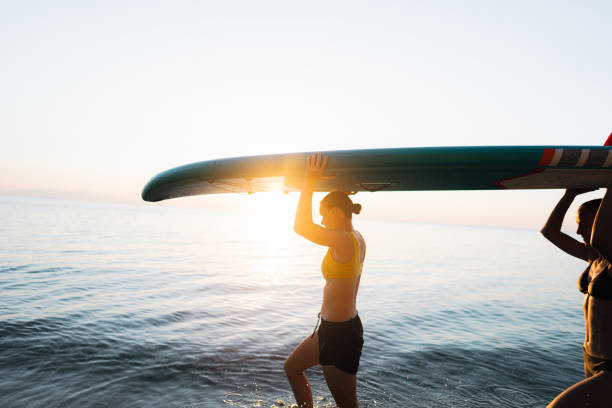 suping do pôr do sol - surfing teenage girls friendship sunset - fotografias e filmes do acervo