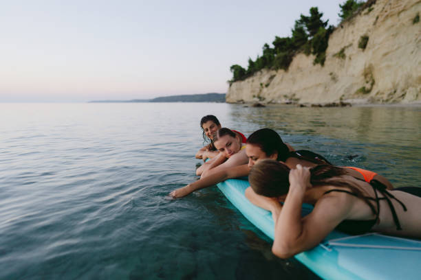 suping na praia - surfing teenage girls friendship sunset - fotografias e filmes do acervo