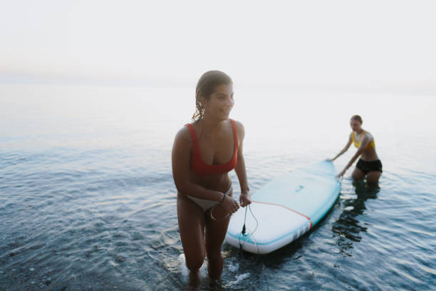suping do pôr do sol - surfing teenage girls friendship sunset - fotografias e filmes do acervo