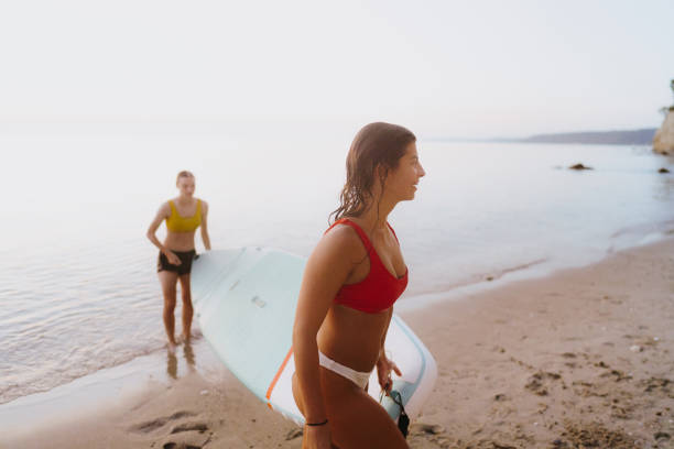 coucher de soleil suping - surfing teenage girls friendship sunset photos et images de collection