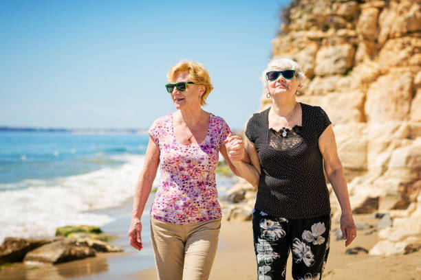 istock Two elderly women are walking along the rocky shore 1471630953