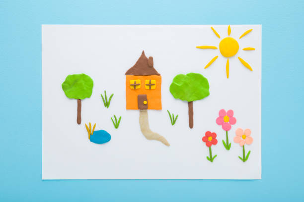istock Home yard with different colorful shapes from modeling clay on white paper on light blue table background. Pastel color. Closeup. Top down view. 1471632561