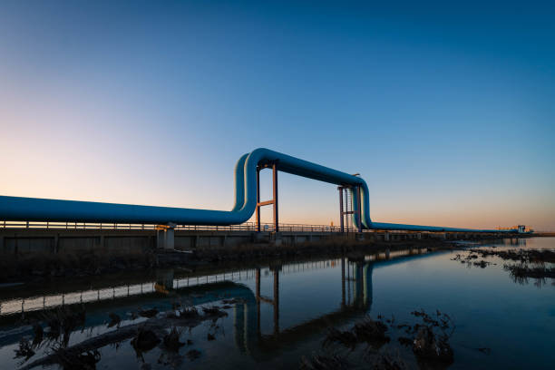 Blue pipes going to oil refinery at sunset