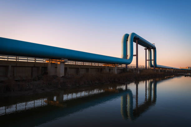 Blue pipes going to oil refinery at sunset stock photo