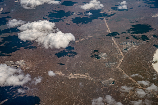 Aerial view of arid dry terrain, with a web of the roads. Aircraft point of view. Eurasia continent