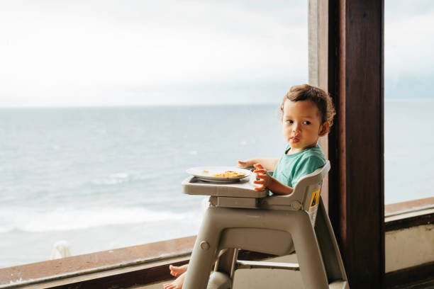 istock baby eating pizza with beach at the view 1471643509