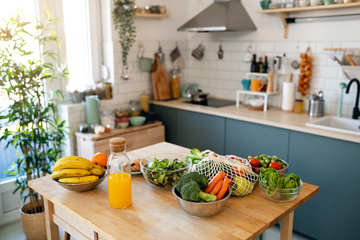 Modern domestic kitchen, with the kitchen island in the center with fresh fruit and vegetables on