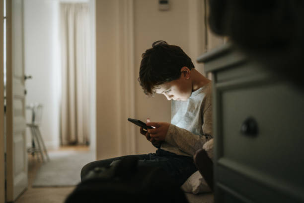Boy playing videogames at home stock photo