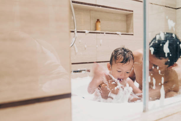 padre e piccolo bambino puliti nella vasca da bagno - bathtub child bathroom baby foto e immagini stock