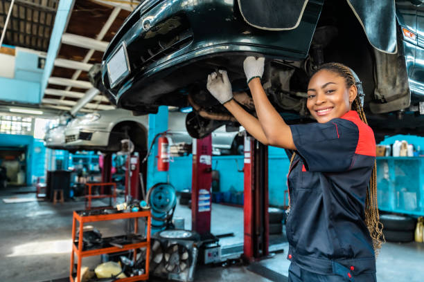 istock Engineer team checking under car condition on lifter in garage.Young auto mechanic in uniform is looking at camera and smiling examining car. 1471646951