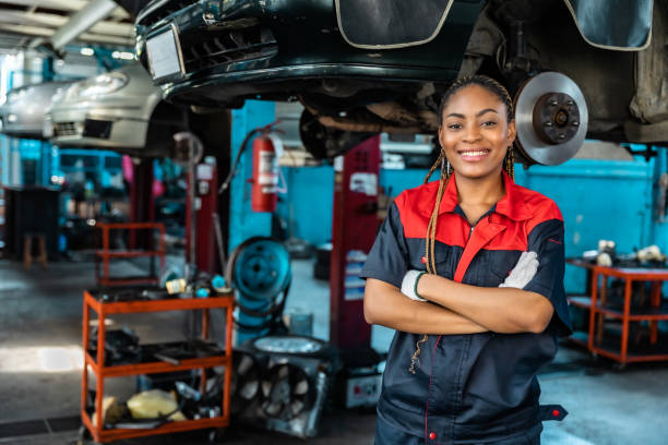 istock Engineer team checking under car condition on lifter in garage.Young auto mechanic in uniform is looking at camera and smiling examining car. 1471646955