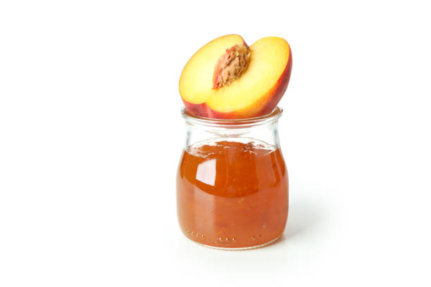 Jar of peach jam and ingredient isolated on white background