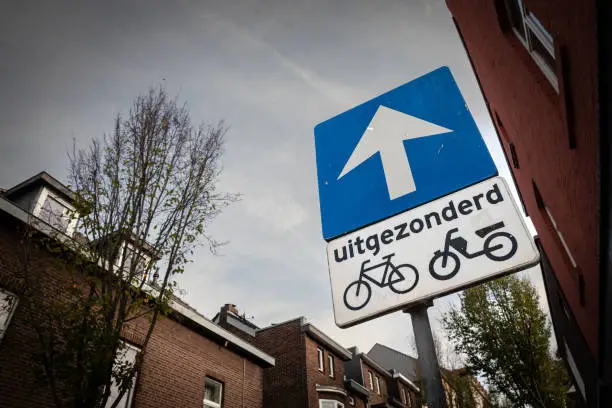 Picture of a dutch roadsign indicating that the street is one way, except for bicycles and motorbikes in the dutch village of Vaals.