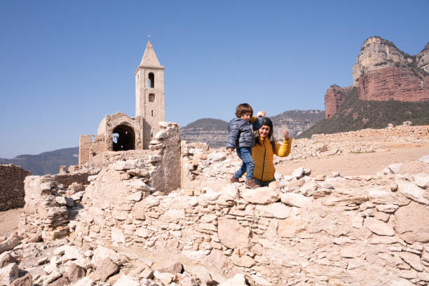A mother and her daughter visit a ruined village in nature