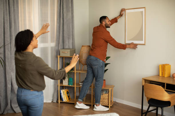 istock Black Couple Hanging Poster In Frame On Wall At Home 1471651311