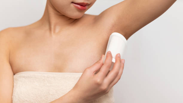 istock Closeup of young lady applying deodorant antiperspirant on armpit, standing over white studio background 1471651382