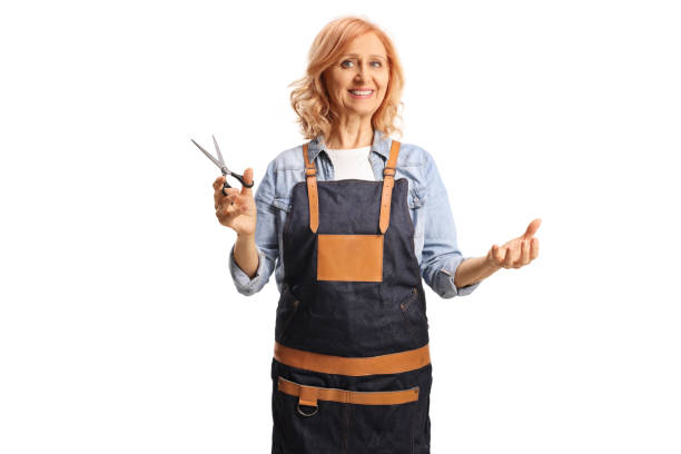 Woman wearing an apron and holding a pair of scissors stock photo