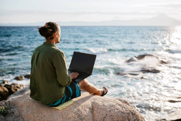 istock Young digital nomad man working by the sea 1471657483