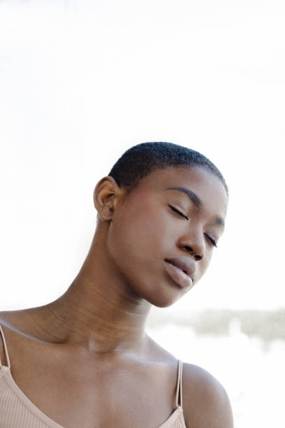 istock Black woman standing with closed eyes against sunlight 1471660798