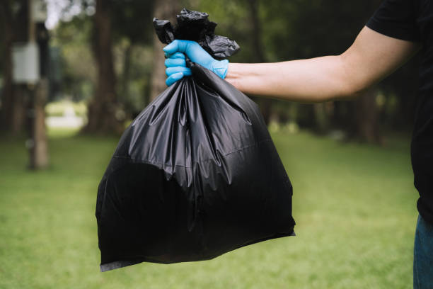 istock Hand holding a black trash bag is putting it into the trash can. 1471662702