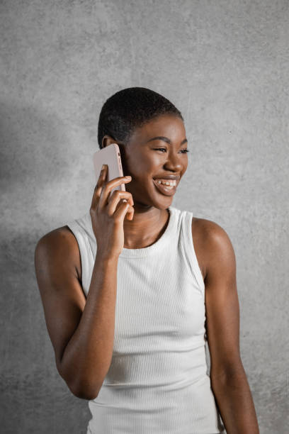 istock Smiling Black woman having phone call looking away while standing 1471662746