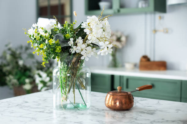 istock Utensil on dining table. Summer white flowers in vase and turk with coffee in kitchen table. Bouquet of flowers and plants in glass vase at home. Home interior with cozy Scandinavian decor. 1471662913
