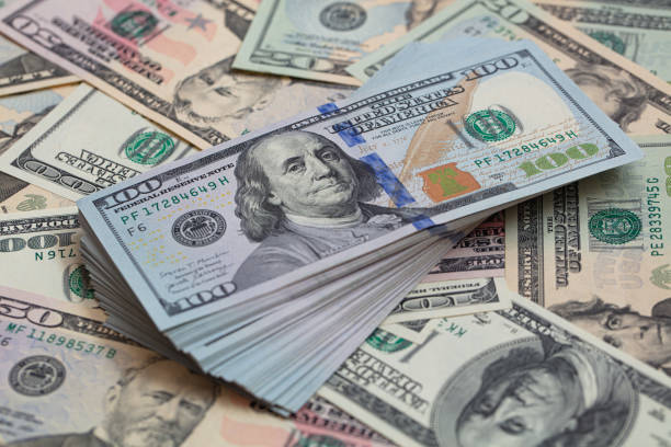 istock Pile of 100 dollar banknotes on dollar background 1471666681