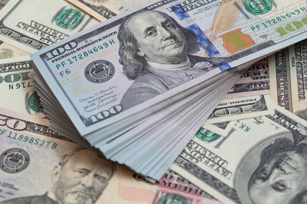 istock Pile of 100 dollar banknotes on dollar background 1471666740