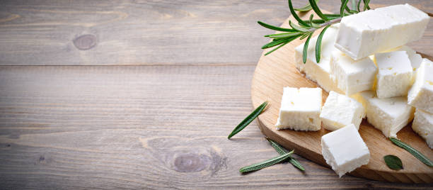 istock Feta cheese with rosemary on wooden background, space for text. 1471668155