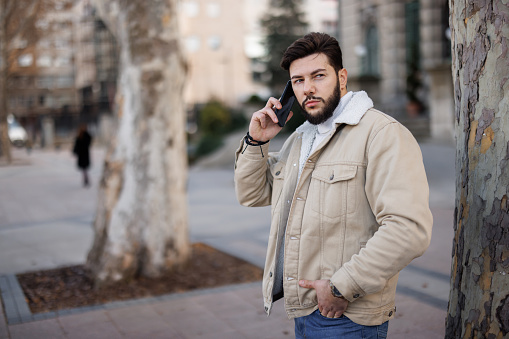 Handsome young man talking on mobile phone in the city