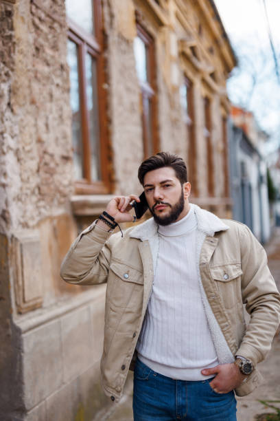 istock Man using smart phone while walking down the street on sunny day in the city 1471672432