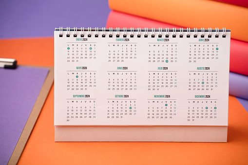 desk calendar with year 2024 and days, on purple and orange desk