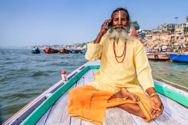 istock Sadhu using mobile in boat on Holy Ganges River, Varanasi 1471673004