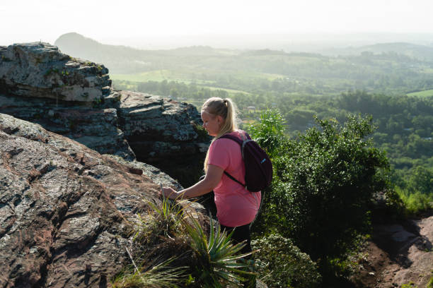 istock young female hiker climbing rock in the forest 1471677948