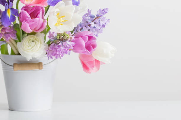 istock spring flowers in bucket on white  background 1471678876