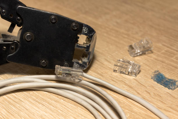 istock Computer network cable, connectrors rj-45 and crimper tool on the wooden table background. Close up, copy space, selective focus 1471680152