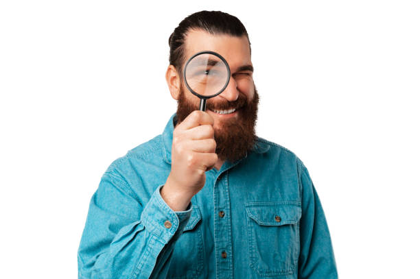 istock Excited bearded man is looking through a magnifying glass at the camera. 1471684760