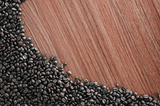 Coffee beans lie on a wooden board with space for text or something.