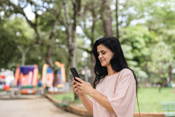 istock Woman using smartphone in city park 1471688649