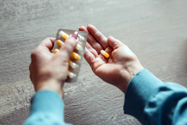 istock High angle view of woman's hands taking medicines at home 1471692081