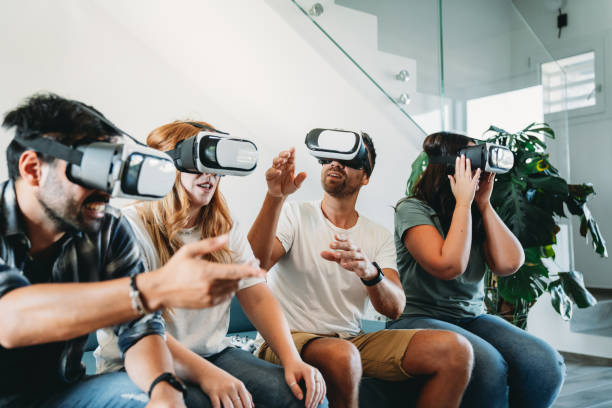 istock Four friends are using virtual reality glasses together on the sofa at home 1471693848