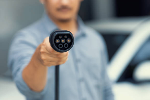 istock Focus progressive EV charger device pointing at camera with blur background. 1471696331
