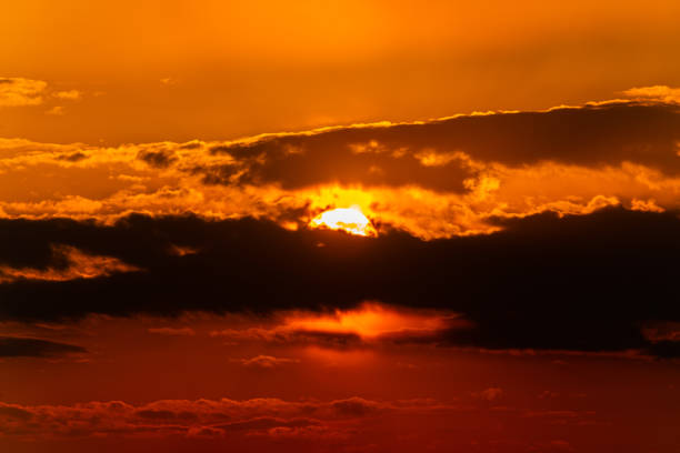 Sun hiding in the clouds at sunset